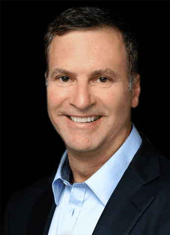 Evan Schlessinger smiling in front of black background