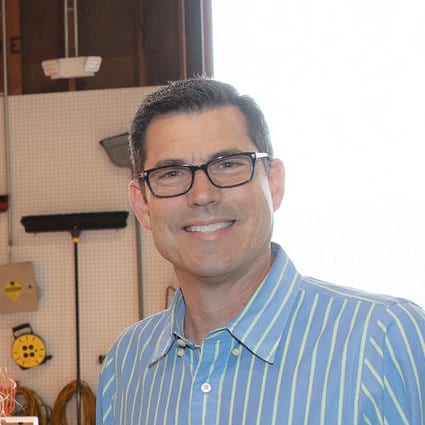 Carl smiling wearing glasses