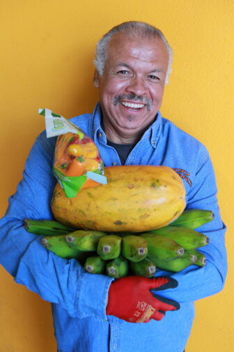 Omar holding fruit and smiling