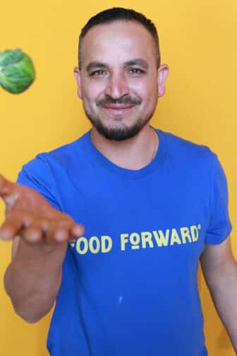 Jorge tossing a brussels sprout in the air